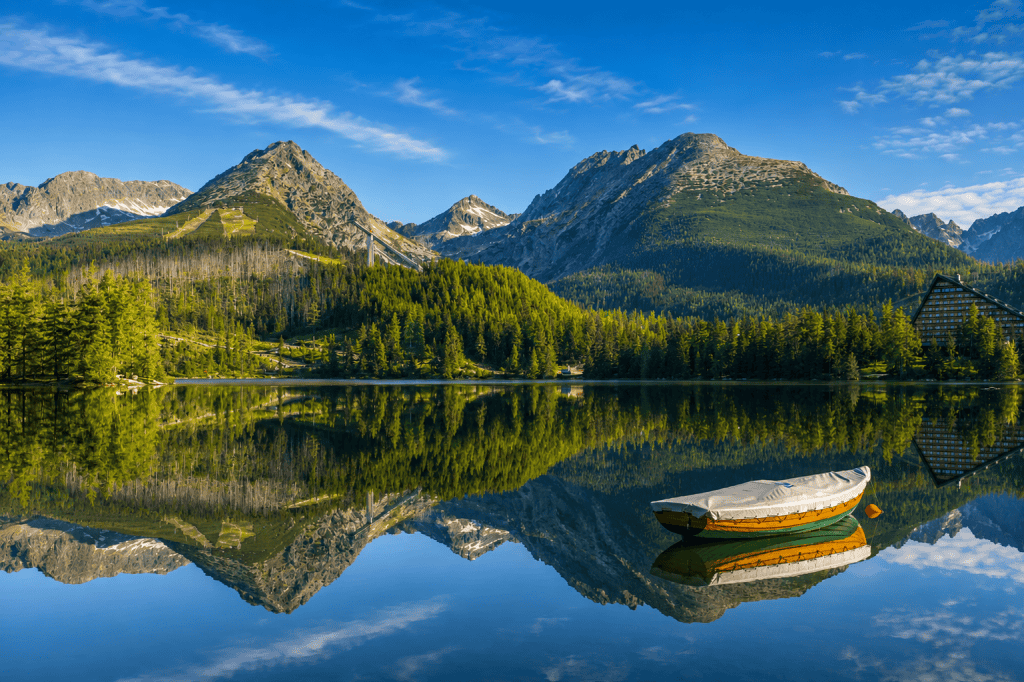 Wooden boat on Strbske Pleso lake below High Tatras mountains