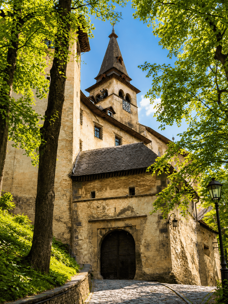 Orava Castle entrance gate and clock tower among trees