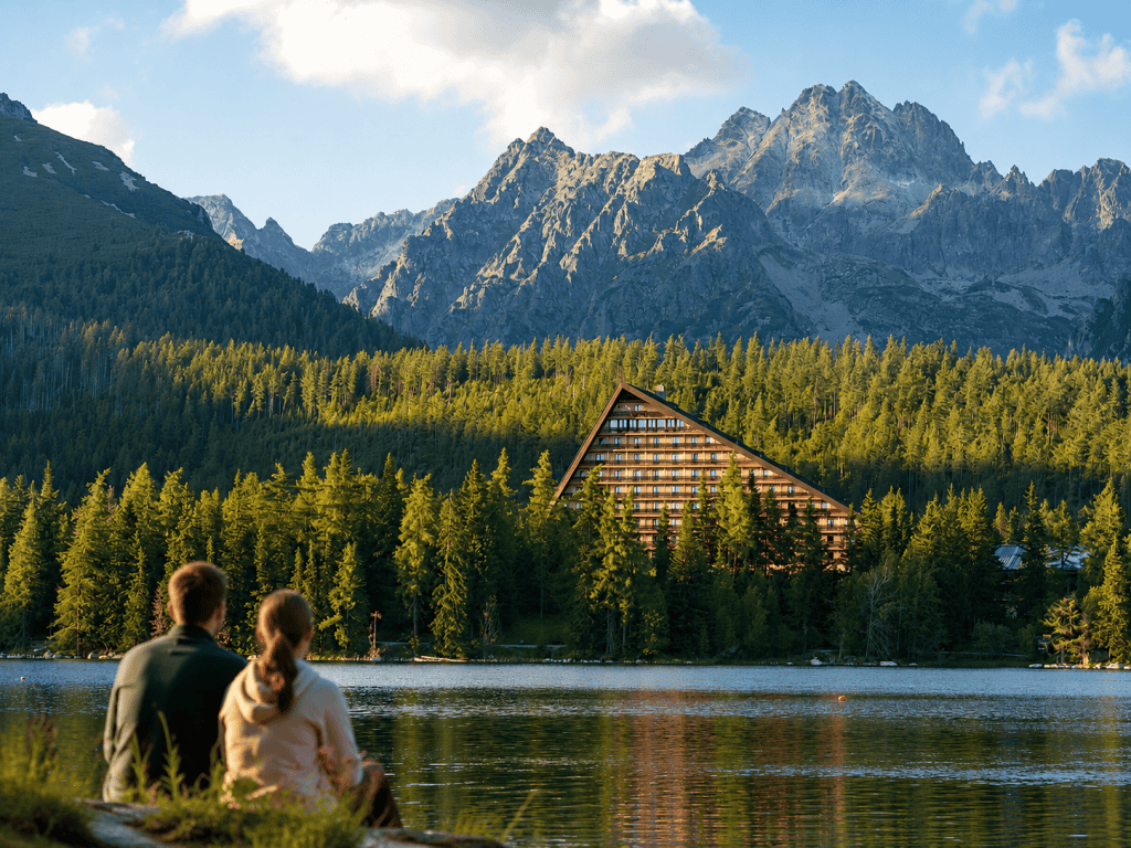 Couple gazing at Strbske Pleso lake beneath High Tatras peaks