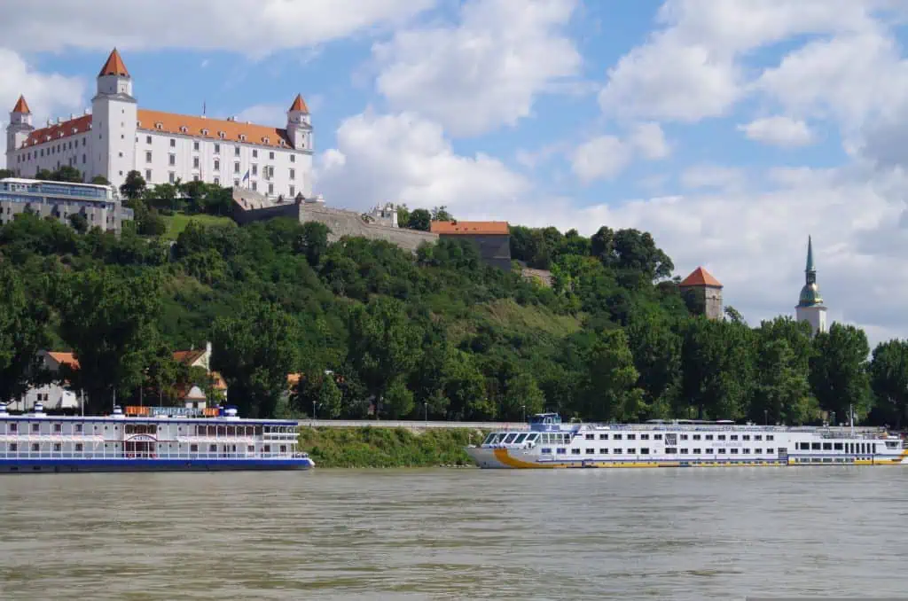 Bratislava Castle above the Danube with a river cruise boat