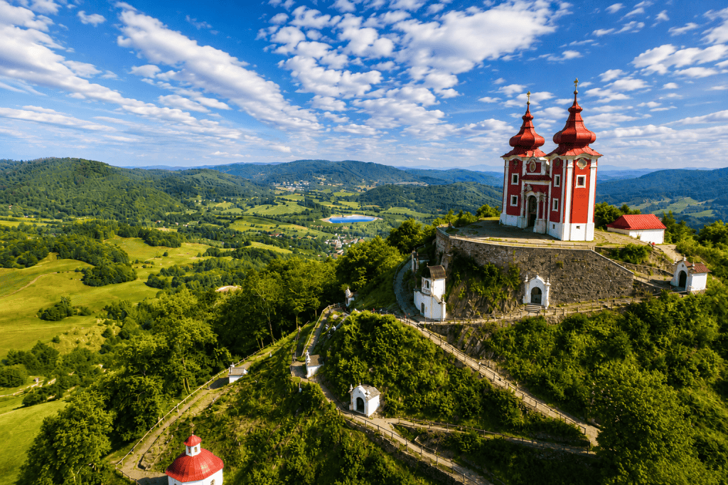 Red-towered Banska Stiavnica Calvary church on a green hilltop