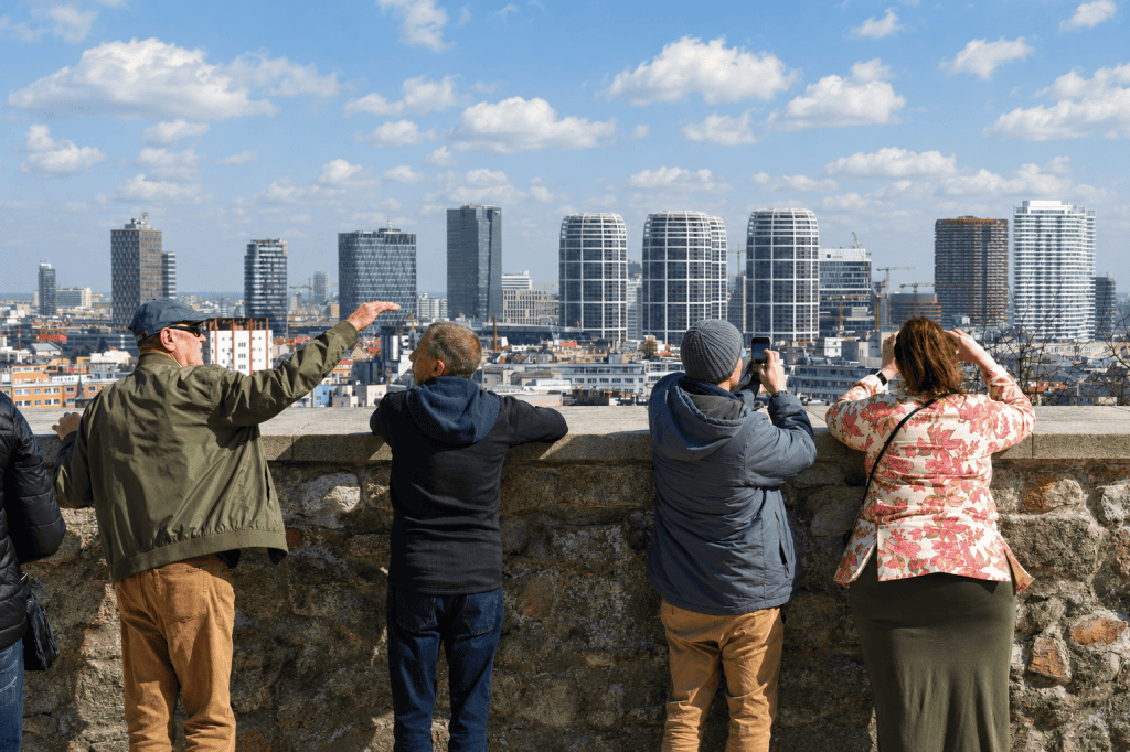 Travelers admiring Bratislava skyline from castle wall viewpoint