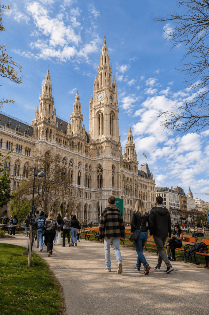 Visitors strolling toward Vienna City Hall gothic towers