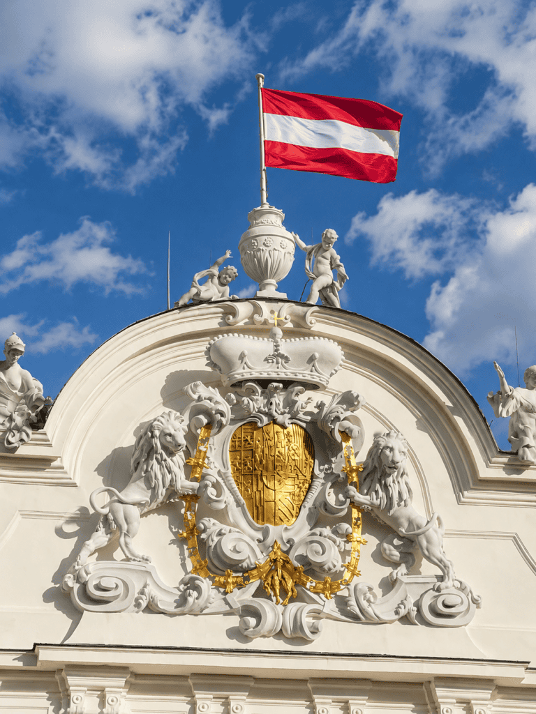 Austrian flag above baroque coat of arms on Belvedere Palace