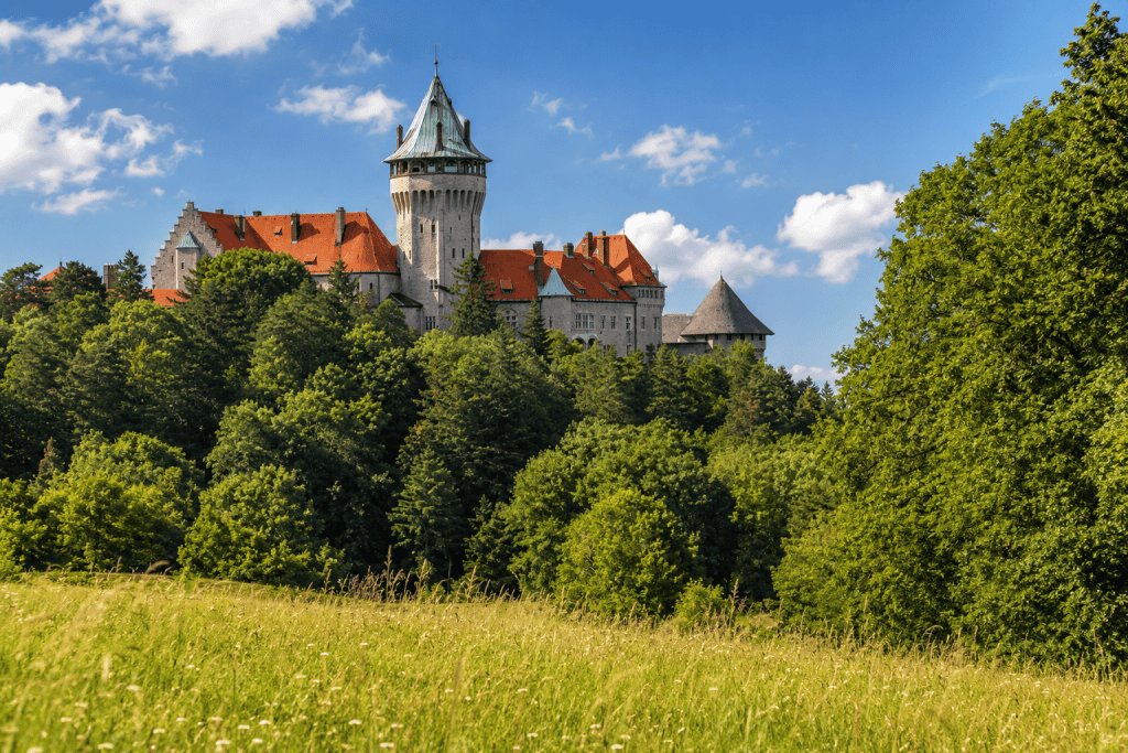 Smolenice Castle towers rising above green summer woodland
